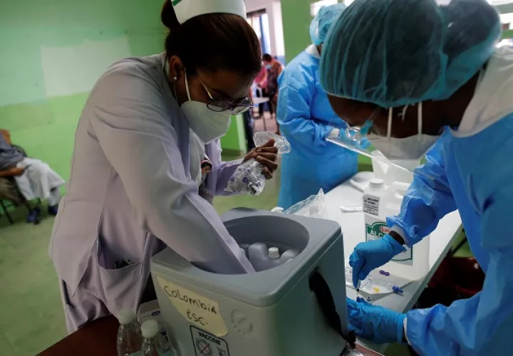 Personal médico prepara vacunas Pfizer contra la covid-19 para aplicar segundas dosis a la población, en la escuela república de Colombia, en San Miguelito. Foto: EFE
