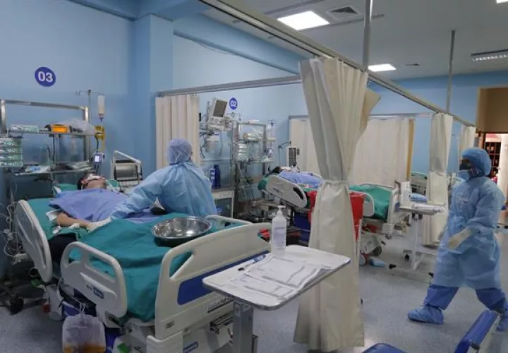Trabajadores de la salud atienden nuevos pacientes covid-19 dentro de la Unidad de Cuidados Intensivos del Hospital Alberto Sabogal en el Callao (Perú).