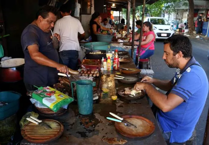 Fotografía del 18 de marzo de 2016 de varias personas comiendo en un mercado de Asunción, Paraguay.