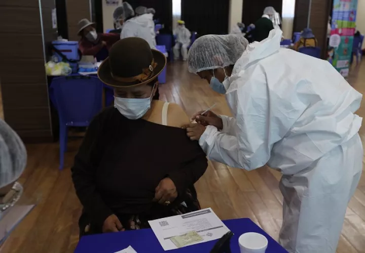 Una funcionaria de salud vacuna contra la covid-19 a una persona en la Escuela Militar de Ingeniería (EMI) en La Paz (Bolivia). Foto: EFE
