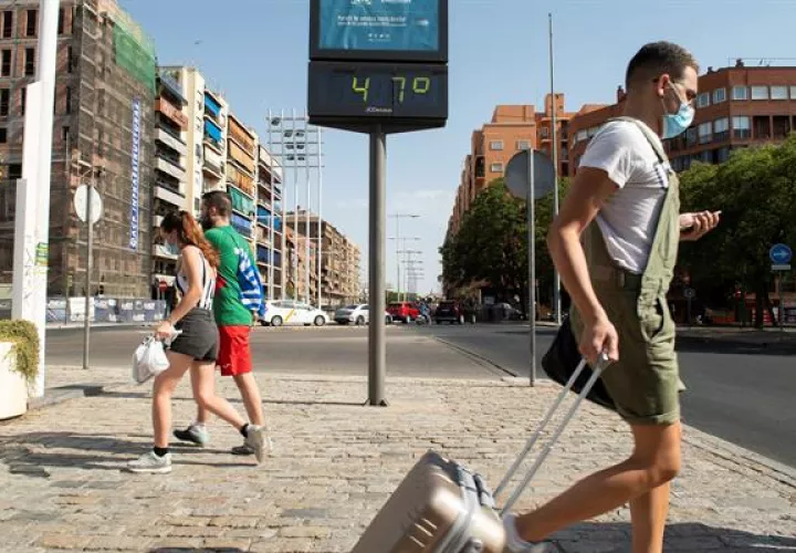 Varias personas pasan ante el termómetro próximo a la estación de autobuses de Plaza de Armas de Sevilla en un día en que las temperaturas máximas superan los 40 grados. Foto:EFE