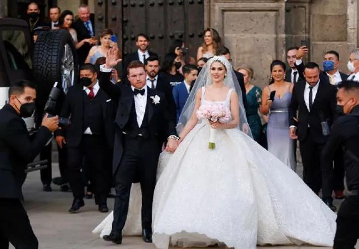 El campeón mundial de peso supermedio de la Asociación Mundial de Boxeo (AMB) y del Consejo Mundial de Boxeo (CMB) Saul "Canelo" Álvarez y su esposa Fernanda Gómez, saludan hoy, al salir de su boda en la catedral de Guadalajara, estado de Jalisco (México). 