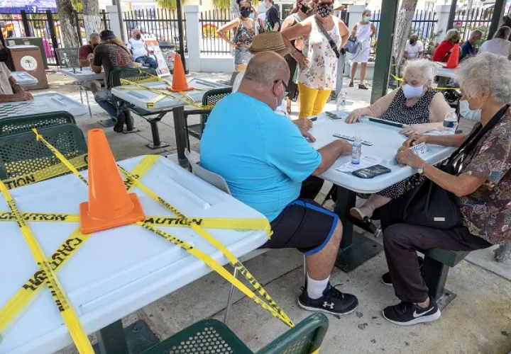 El coronavirus no ha impedido que los amantes del dominó jueguen en el Domino Park en el barrio de La Pequeña Habana, Miami, Florida, Estados Unidos. Foto: EFE