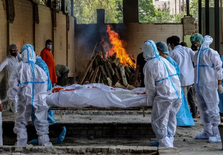 Las personas realizan los últimos ritos de una víctima de covid-19 en un campo de cremación en Nueva Delhi, India. Foto: EFE