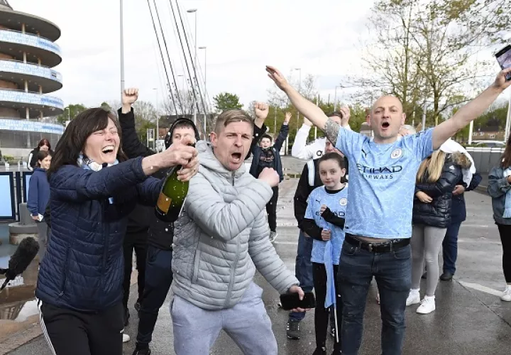 Los seguidores del Manchester City celebran que su club ganó el título de la Premier League, después de que el Manchester United perdiera ante el Leicester. Foto: EFE