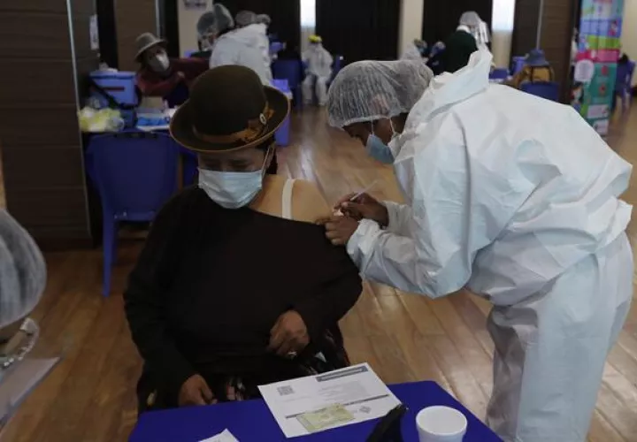 Una funcionaria de salud vacuna a una persona en un punto de vacunación masiva contra la covid-19 en la Escuela Militar de Ingenieria (EMI) en La Paz (Bolivia). EFE
