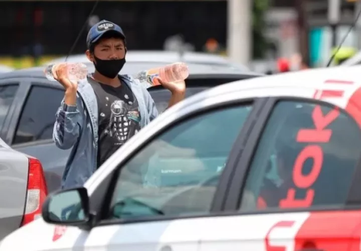 Un adolescente vende bebidas entre las filas de vehículos en Ciudad de México  Foto: EFE