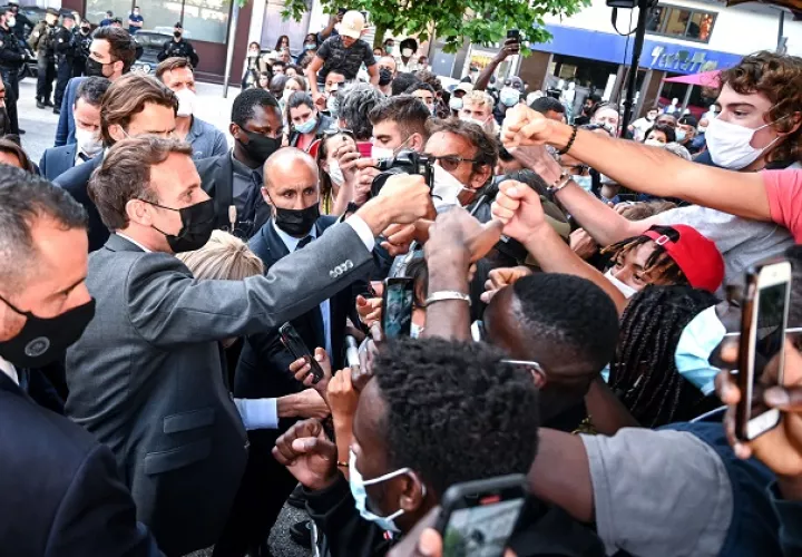 Emmanuel Macron (izq.) saluda, como es su costumbre, a miembros de una multitud durante su visita a Valence, Francia. Foto: EFE
