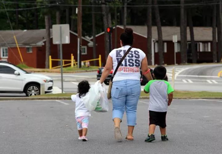 Una mujer camina con dos niños de la mano en Estados Unidos. Foto: EFE