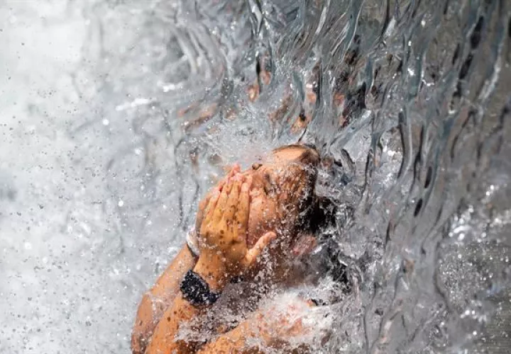 Una persona se refresca bajo una cascada en un parque en Washington, DC, Estados Unidos, este 30 de junio de 2021. Foto: EFE