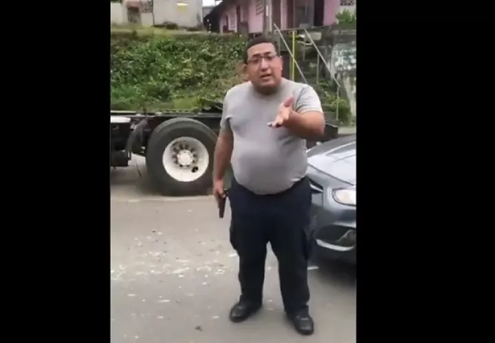 El agente policial, con arma de fuego en mano, no le importó que lo estuvieran grabando. 