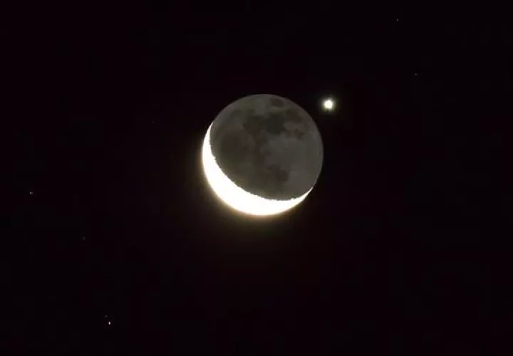El planeta Venus ocultándose tras una delgada luna creciente. Foto: EFE