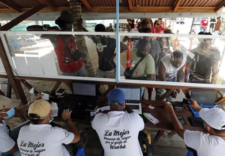 Fotografía tomada el pasado 3 de mayo en la que se registró a decenas de migrantes, de diversas partes del mundo, al comprar tiquetes para viajar a Capurganá, en el embarcadero de Necoclí (Colombia).