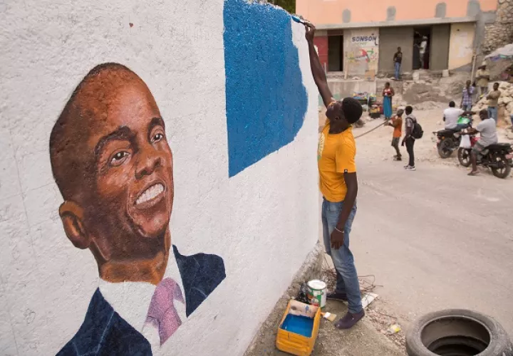 Un hombre pinta un mural en homenaje al presidente Jovenel Moise, en Puerto Príncipe, Haití. Foto: EFE