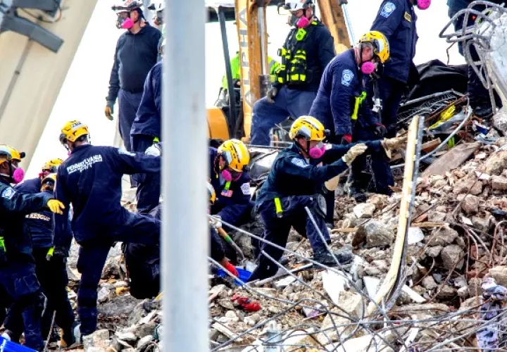 Miembros de equipos de rescate fueron registrados este lunes al reanudar sus labores sobre los escombros del edificio Champlain Towers South. Foto: EFE