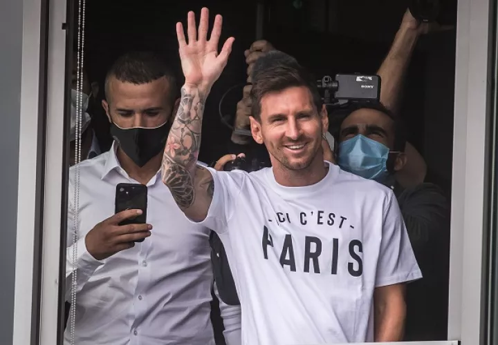 Lionel Messi saludó desde un primer piso del aeropuerto en París a los eufóricos hinchas que le aguardaban, quienes gritaban "Messi, Messi". Foto: EFE