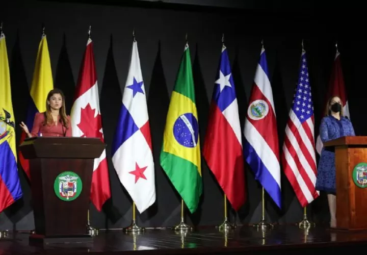 La canciller y la directora de Migración dan detalles de lo discutido en la reunión, con las banderas de los países participantes, al fondo. Foto: Cortesía Cancillería 