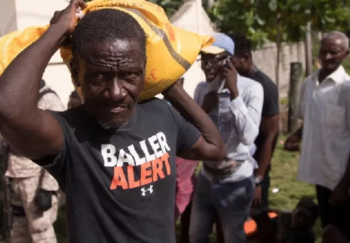 Un hombre carga ayuda humanitaria entregada por una entidad privada hoy, en las afueras de Les Cayes (Haití). Foto: EFE