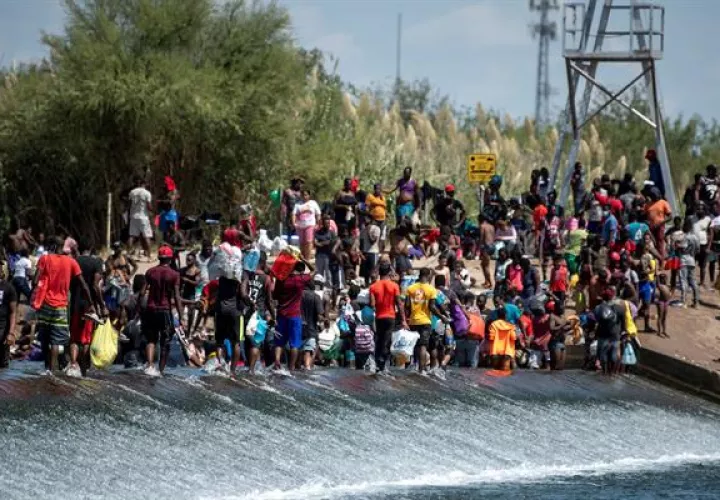 Migrantes procedentes de Haití esperan ayer en el río Bravo para cruzar rumbo a Estados Unidos, en Ciudad Acuña, estado de Coahuila (México). EFE