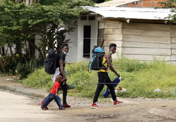 Migrantes caminan por la localidad colombiana de Necoclí, en la frontera con Panamá. Foto: EFE