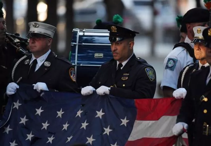 Policías y bomberos de Nueva York sostienen la bandera de Estados Unidos durante el himno nacional en una ceremonia de conmemoración de los atentados del 11S en el World Trade Center, en Nueva York (EE.UU.), este 11 de septiembre de 2021. Foto: EFE