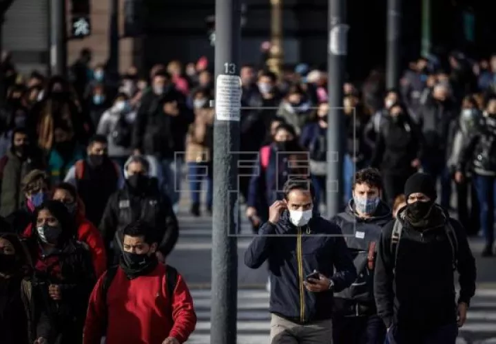 Personas caminan frente a la estación ferroviaria de Constitución protegidos con mascarillas, en Buenos Aires, Argentina. Foto: EFE