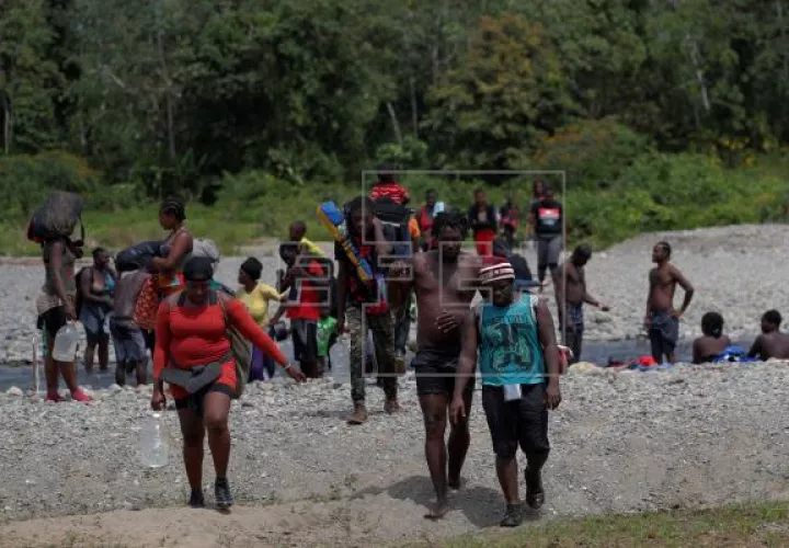 Migrantes haitianos caminan a través del río turquesa hacía la comunidad de Bajo Chiquito, en la provincia de Darién. Foto: EFE
