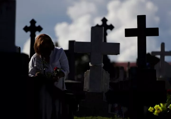 Una mujer deposita flores en el Cementerio de Amador durante el Día de los Difuntos en ciudad de Panamá. Foto: EFE