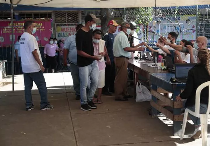 Un grupo de personas se prepara para votar en la junta receptora de votos durante las elecciones presidenciales en Managua. Foto: EFE
