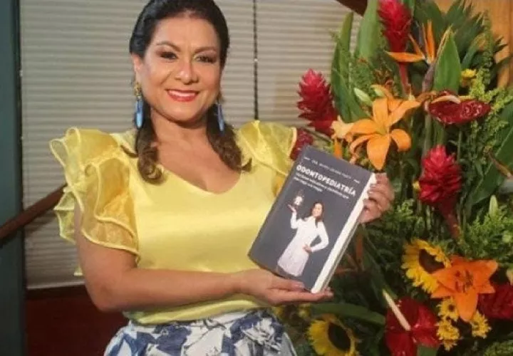 La odontopediatra y docente Mayuli Arjona posando con su libro. Foto: Cortesía