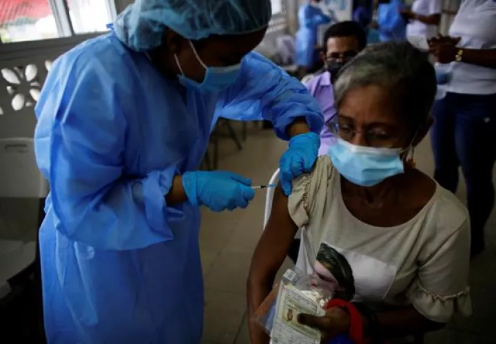Personal médico mientras coloca la tercera dosis con la vacuna Pfizer en el centro de salud de El Chorrillo en Ciudad de Panamá.