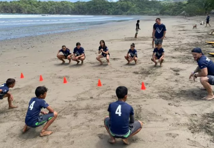 Nils Lleonart, coordinador de surf dando algunas instrucciones a los estudiantes en la playa.
