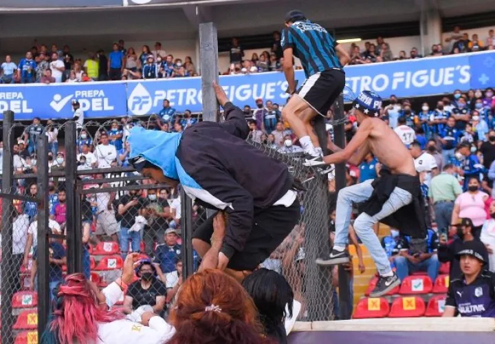Aficionados se lanzan a la cancha durantel el partido Querétaro- Atlas. Foto:EFE