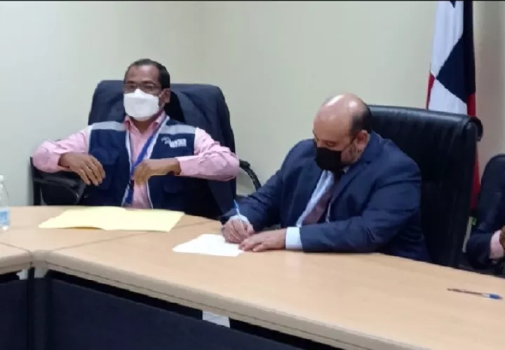 Momento en que el director encargado de la Autoridad del Tránsito, Carlos Ordoñez, firma el acuerdo de tres puntos al que se llegó con los transportistas. Foto: Francisco Paz