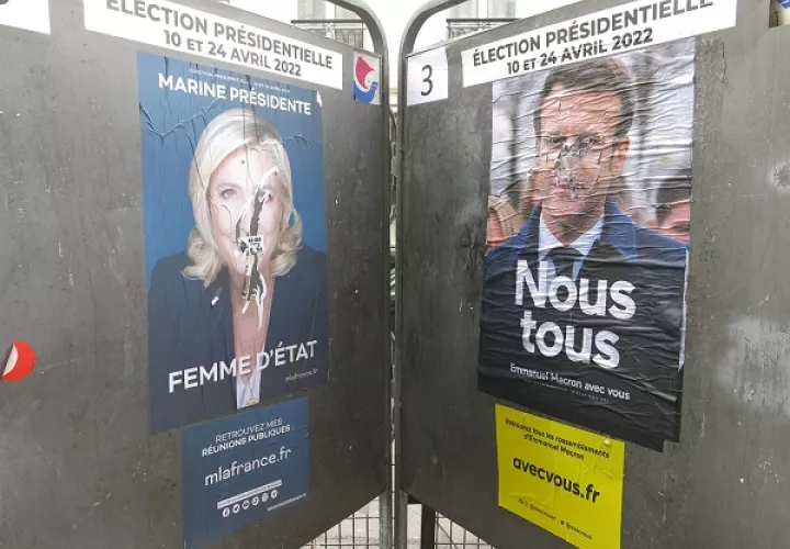 Dos carteles electorales de Emmanuel Macron y Marine Le Pen se "enfrentan" también en las calles de París. EFE/Rafael Cañas