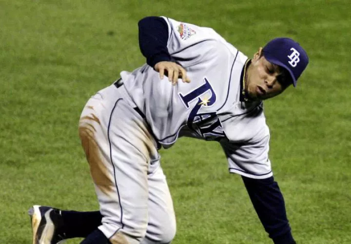El jugador de los Rays de Tampa Bay Akinori Iwamura comete un error al dejar escapar una bola de Jimmy Rollins de los Fílis de Filadelfia. Foto: EFE / Chris Gardner 