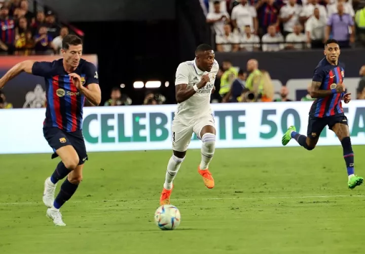 Robert Lewandowski (izq)  y Raphinha (der) del Barcelona, junto a  David Alaba  de Real Madrid. Foto: EFE