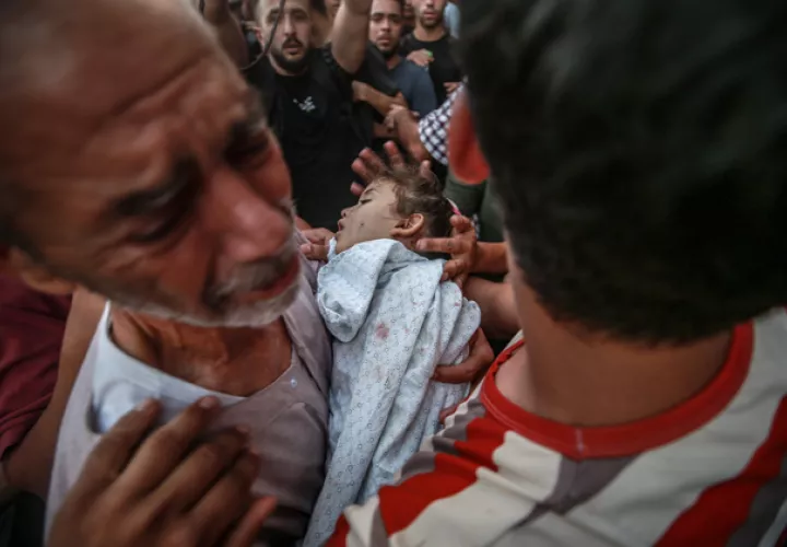 El abuelo del niño Alaa Qadoum, de cinco años, llora mientras carga su cuerpo durante su funeral. Foto:EFE