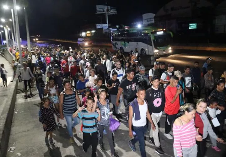 Migrantes de diversas nacionalidades caminan en caravana hoy, en Tapachula