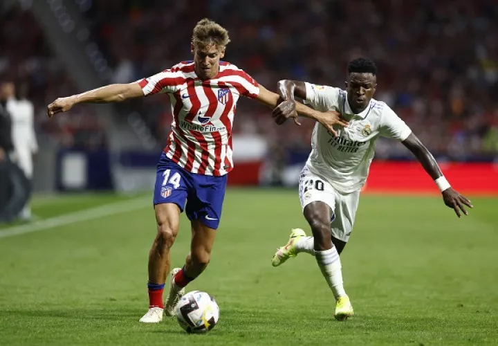 El centrocampista del Atlético de Madrid, Marcos Llorente (izq.), conduce el balón ante el delantero brasileño del Real Madrid, Vinicius Jr.. Foto:EFE