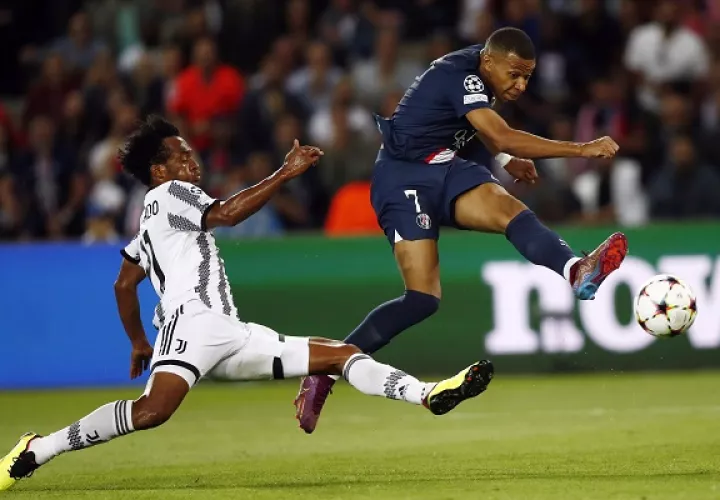 Juan Guillermo Cuadrado  de la Juventus (izq.)  intenta marcar a Kylian Mbappe del PSG  en el partido entre ambos en la Champions. Foto:EFE