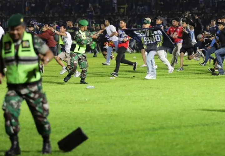 Fanáticos y policía en el estadio Kanjuruhan en  Indonesia. Foto:EFE 