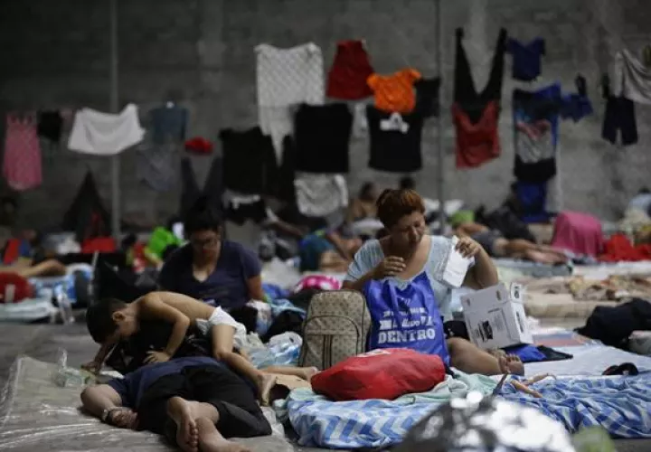 Personas migrantes de origen venezolano, incluidos niños, descansan en un refugio temporal.