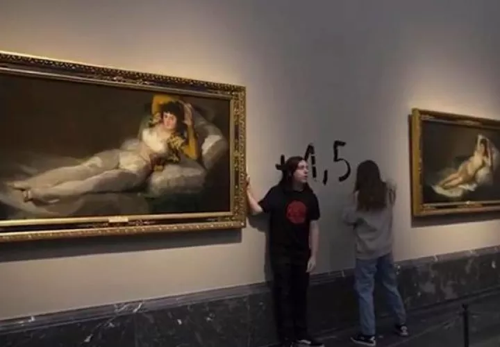 Activistas de la organización Futuro Vegetal se pegan a los marcos de los cuadros de "La maja vestida" y "La maja desnuda". Foto: EFE
