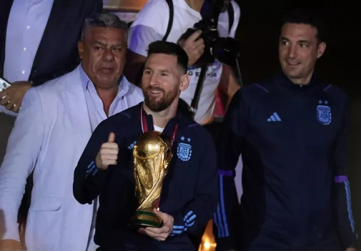 Messi con el trofeo de campeón del mundo, el técnico Scaloni (der.)  y Claudio 'Chiqui' Tapia de la AFA. Foto:EFE