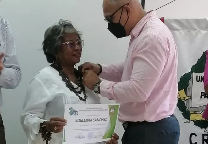 El Ing. Andrés Chang poniendo el pin conmemorativo a Edelmira Sánchez. Foto: Cortesía