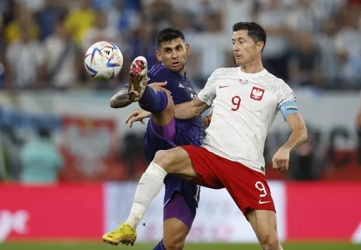 Robert Lewandowski de Polonia (9) disputa un balón con Cristian Romero de Argentina. Foto: EFE
