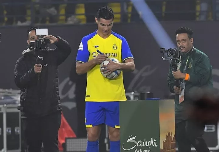 Cristiano firma un balón para los aficionado en su nuevo club Al Nassr. Foto:EFE