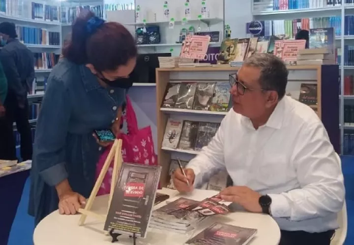 René Morales Cortés firmando copias de su publicación en la Feria del Libro. Foto: Cortesía