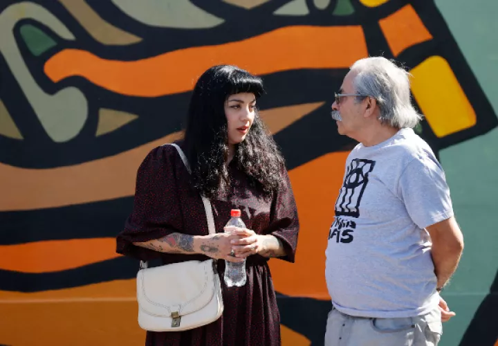 Mon Laferte(i) y Alejandro 'Mono' González (d) conversan durante la inauguración de su mural. Foto: EFE / Elvis González